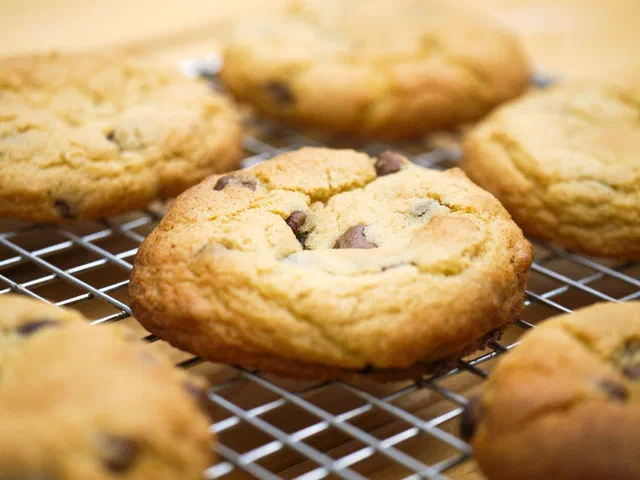 Des cookies dorés aux pépites de chocolat qui refroidissent sur une grille