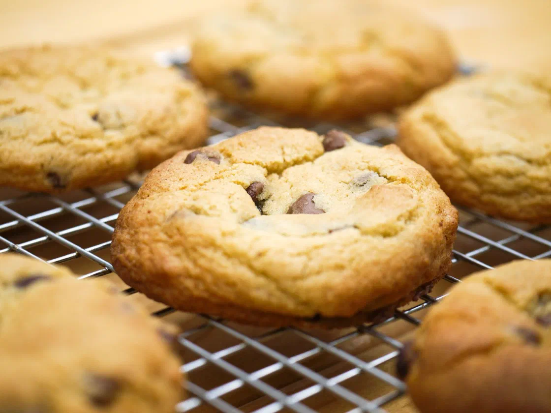 Des cookies dorés aux pépites de chocolat qui refroidissent sur une grille