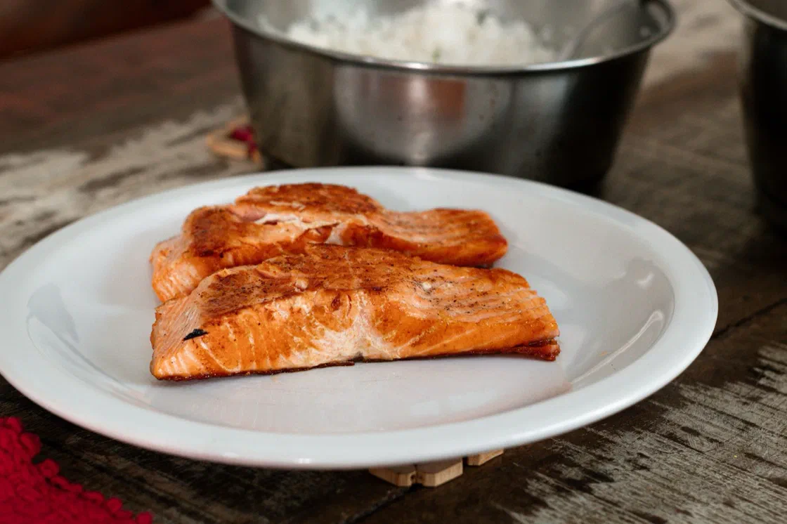 Deux pavés de saumon cuits et dorés sur une assiette blanche