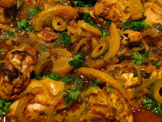Morceaux de poulet en sauce dorée avec des lamelles de citron confit, des olives vertes et du persil